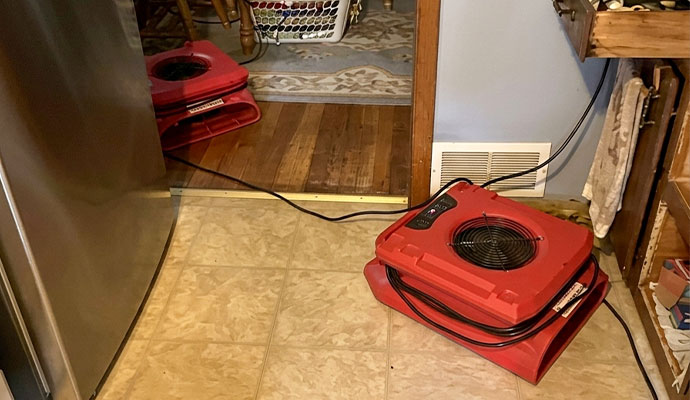 Air movers drying wet kitchen floor tiles