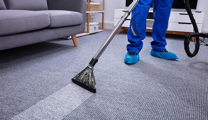 Technician deep cleaning carpet to remove dirt and stains