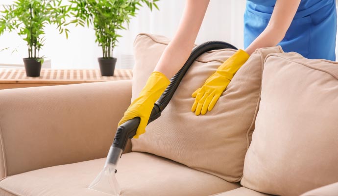 Person cleaning upholstery with equipment