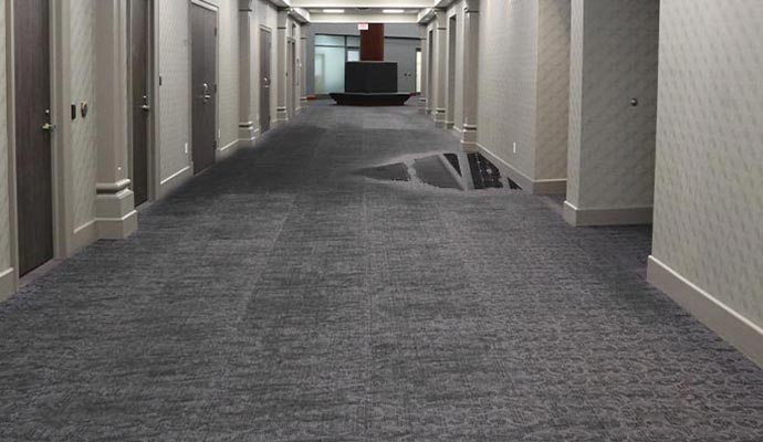 Water damaged carpet in hotel corridor