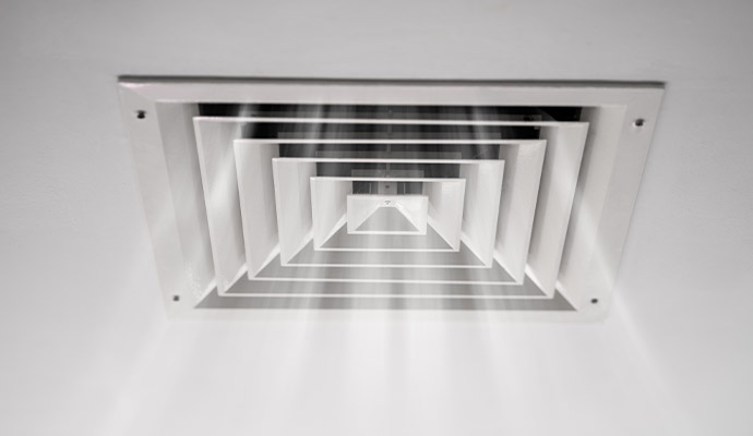 A white square multi-cone ceiling air vent