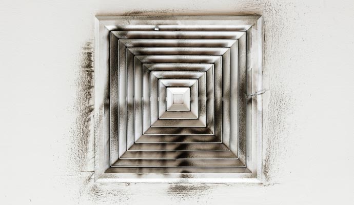 Dirty air duct vent on a white ceiling