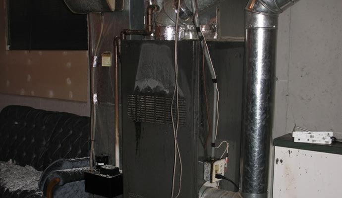 Damaged furnace unit with soot and fire residue.