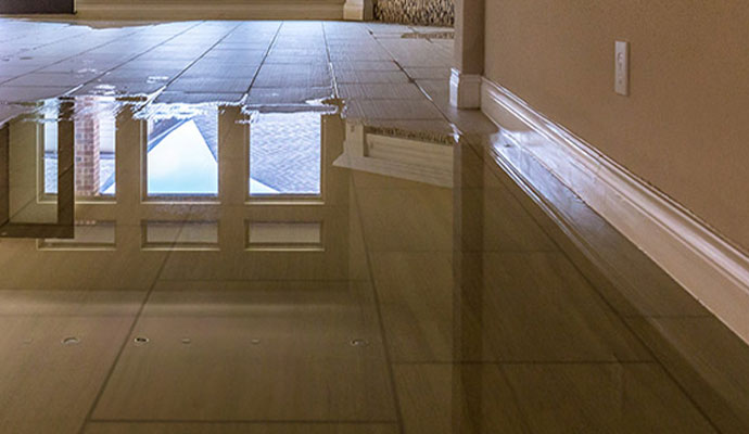 Standing water flooding a tiled floor inside a property after firefighting water suppression
