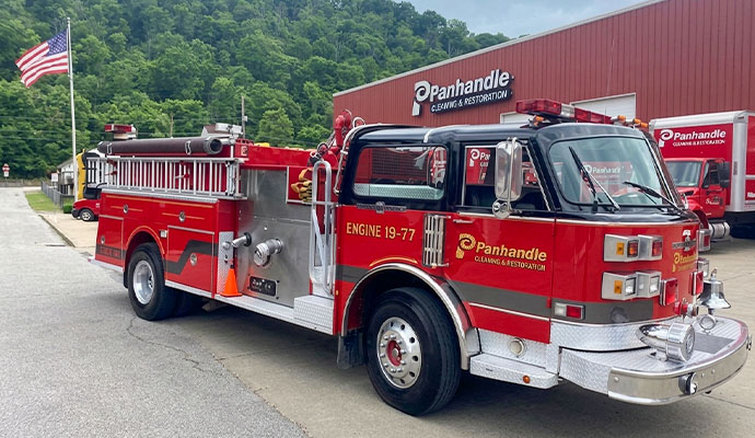Red Panhandle Cleaning & Restoration fire engine truck parked outside facility