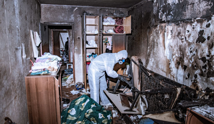 Restoration technician cleaning fire damaged room