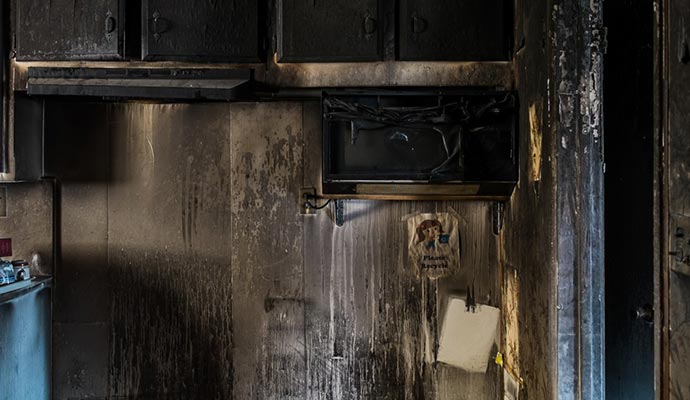 Soot damaged kitchen with stain and burnt appliances