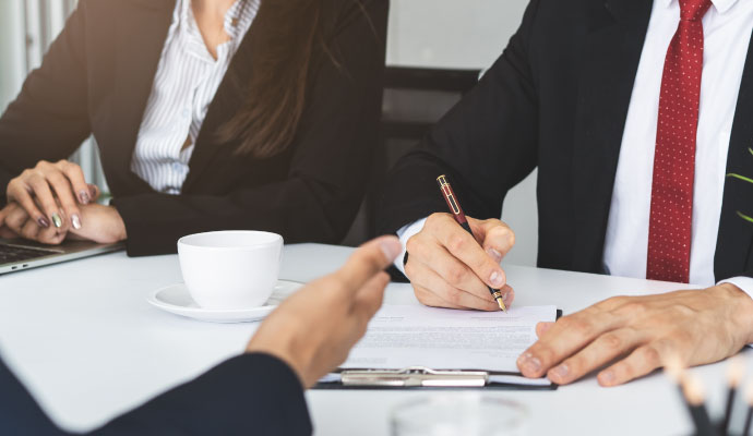 Insurance adjuster signing damage claim documents with client