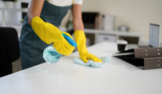 Janitorial worker cleaning office desk