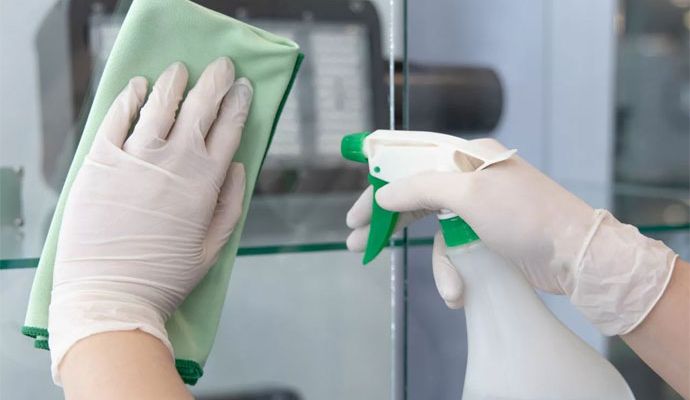 Professional maid cleaning glass