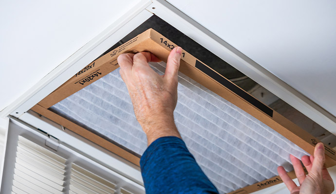 Person installing new air vent filter