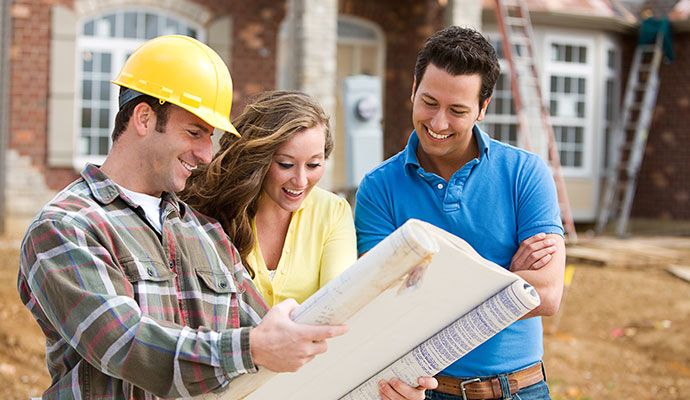 Contractors and clients discuss architectural plans for a new home construction project.