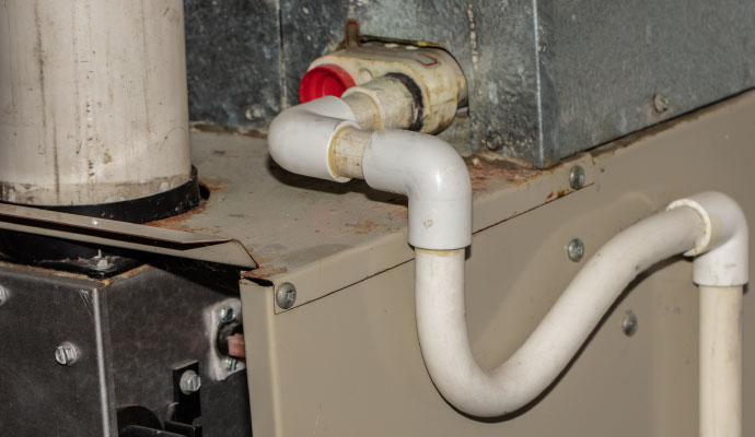 PVC condensate drain line connected to an indoor AC unit