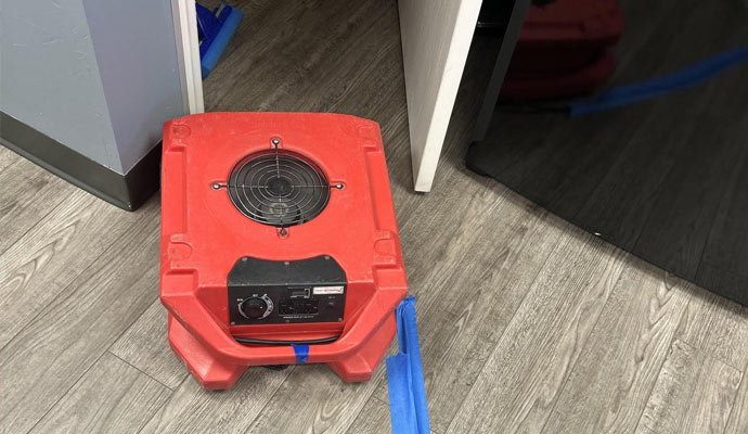 A red floor air mover on the doorway
