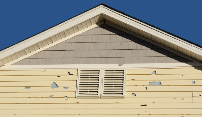 Hail damaged house with cracked siding
