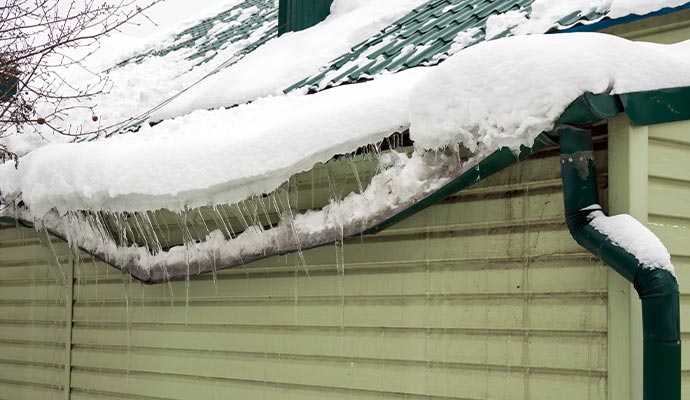 Ice accumulation bending and damaging metal roof gutters.