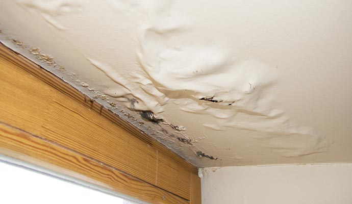 Water soaked sagging ceiling with visible drywall damage.