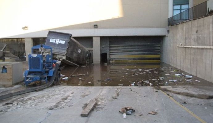 Flooded commercial loading dock with damaged truck