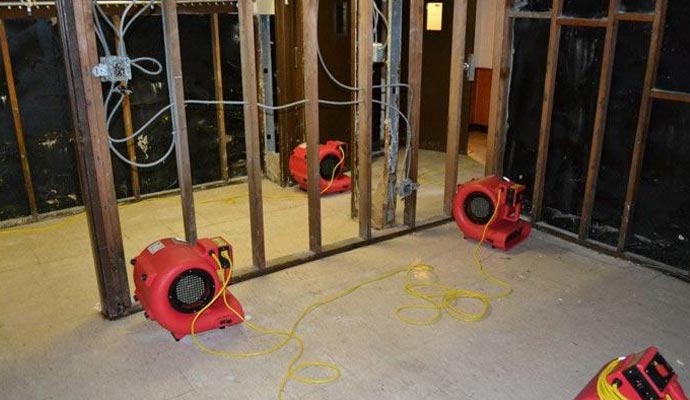 Professional air movers drying a water-damaged room.